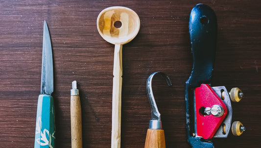 a wooden spoon and the tools used to carve it