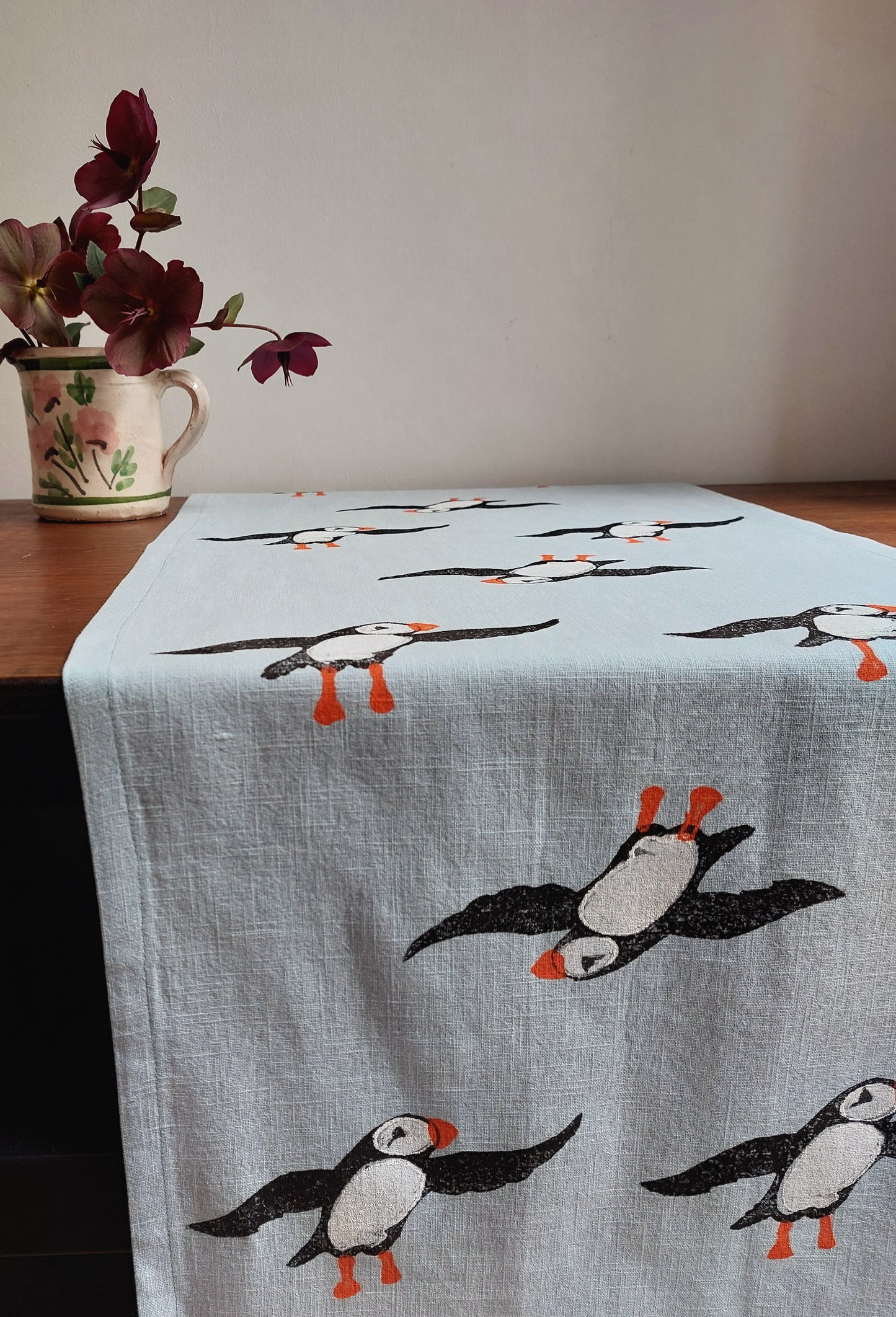 table runner perky puffin on pale blue linen