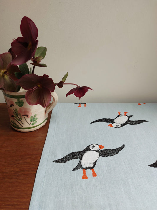 table runner perky puffin on pale blue linen