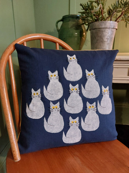 white cats on navy cushion