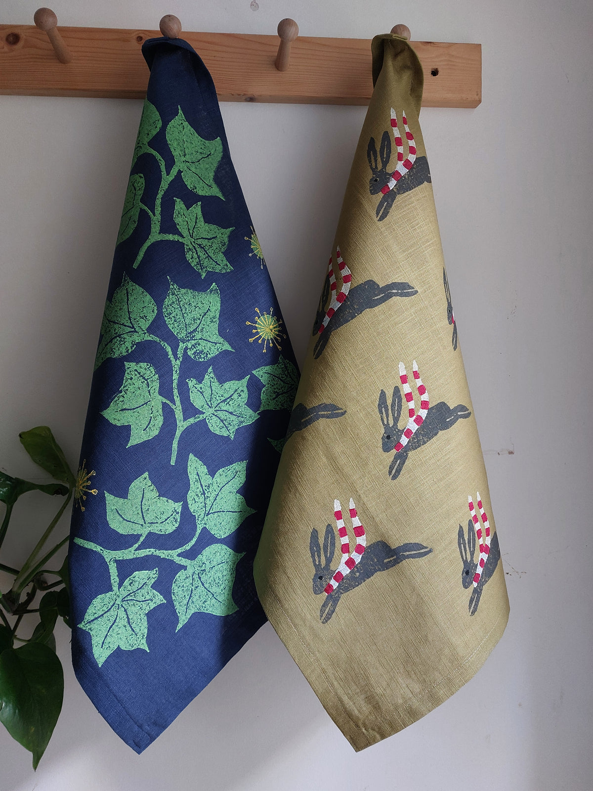 leaping winter hare tea towel green