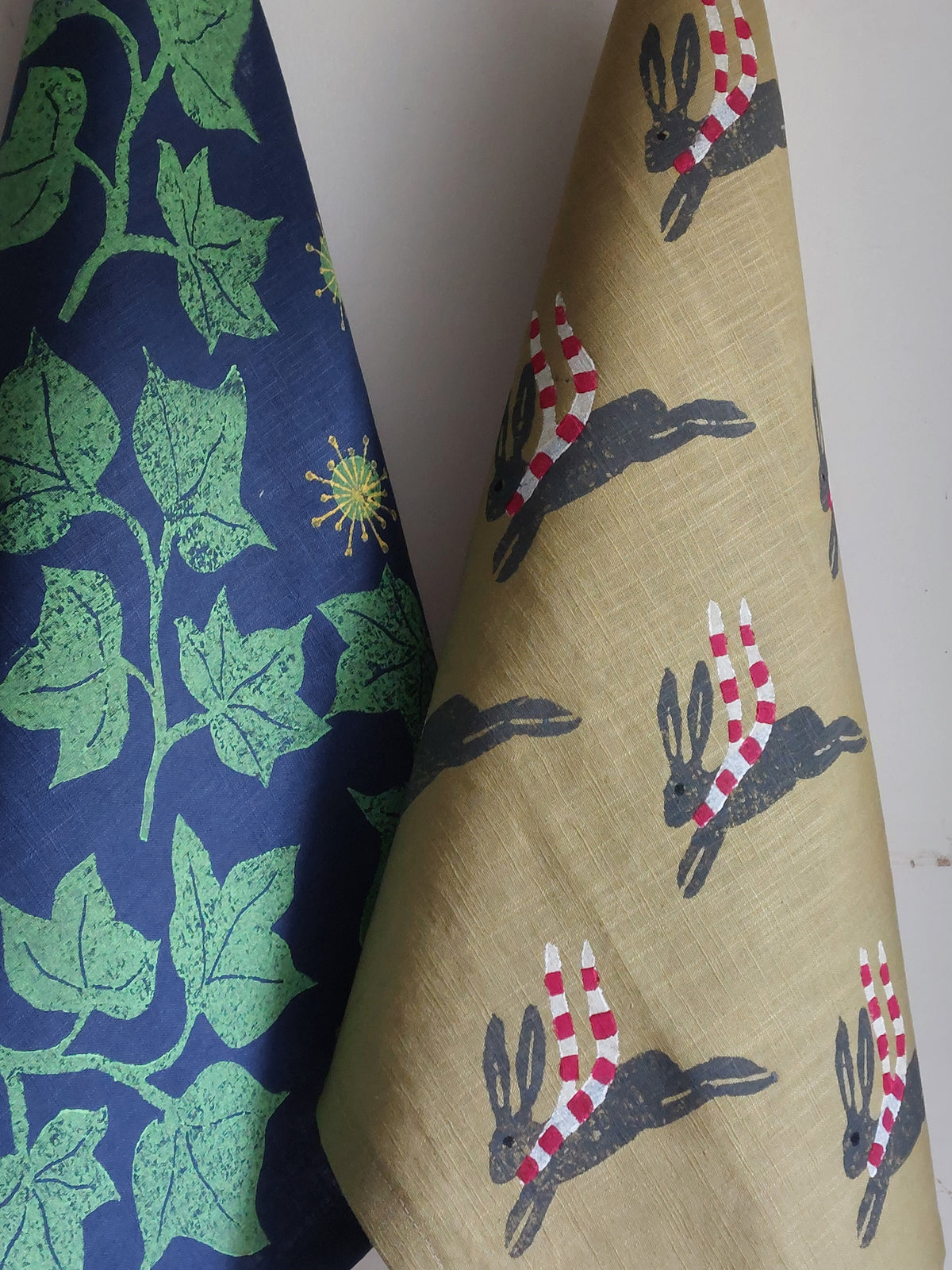leaping winter hare tea towel green
