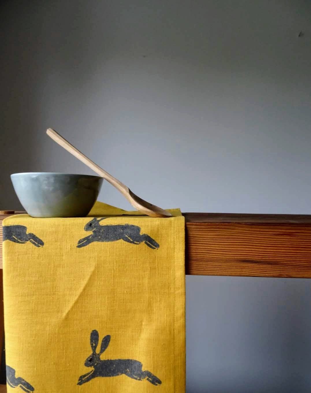 hare on mustard linen tea towel